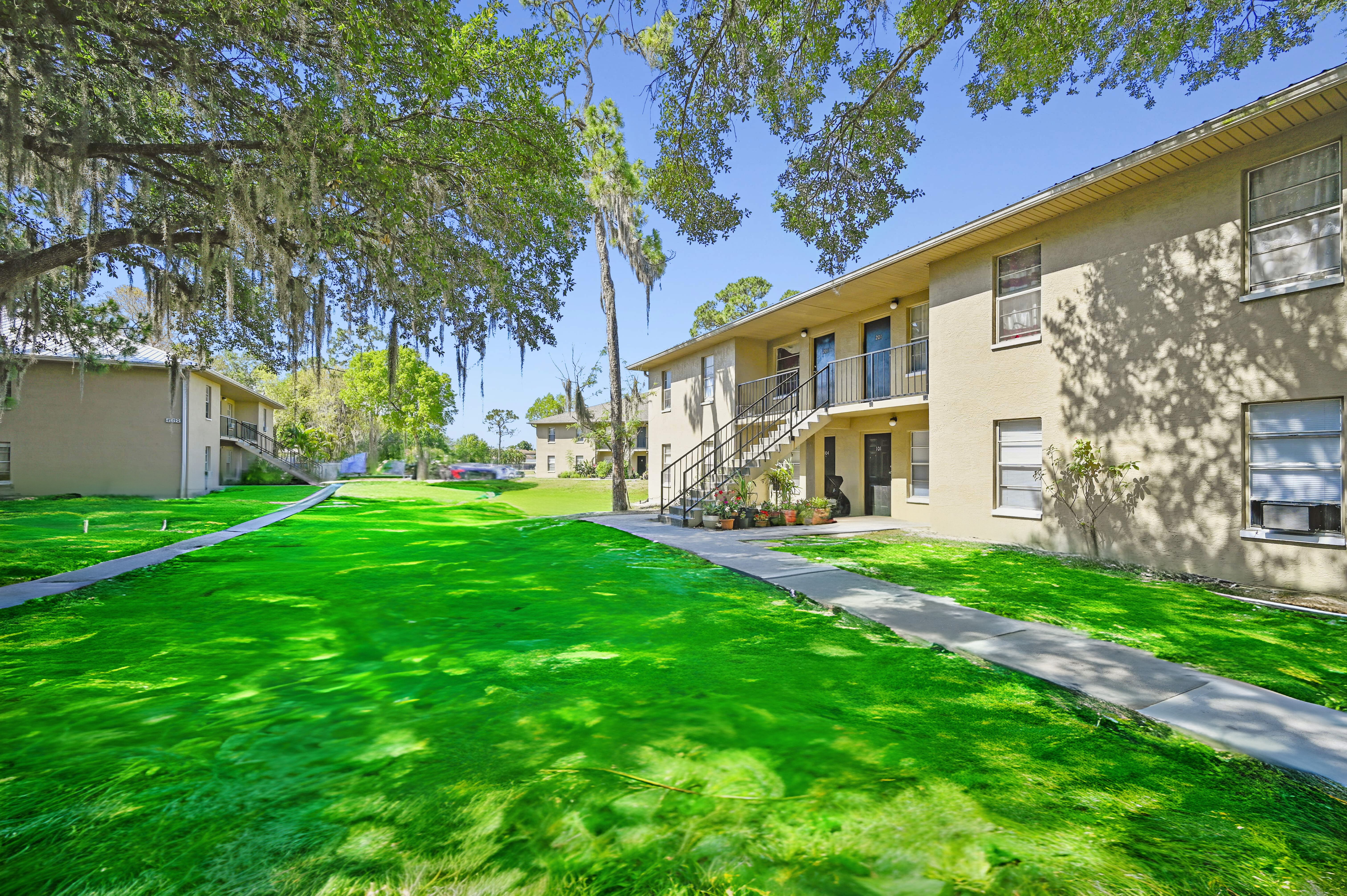 A sunny day at a residential area with apartment buildings and green lawns.